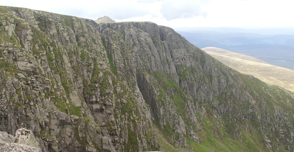 Looking West at the cliff, with the summit in the background Looking West at the cliff, with the summit in the background